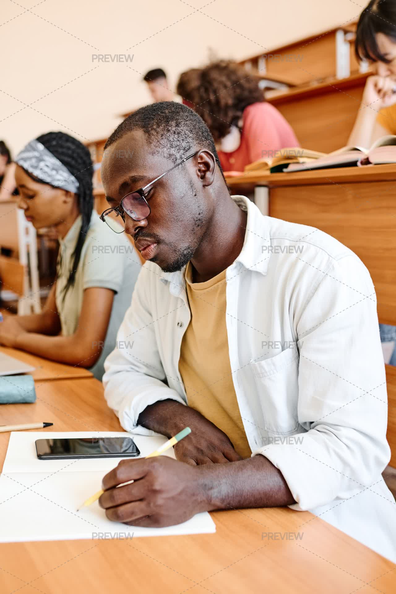 Student Writing In Exam Student Writing Exam At Auditorium by AnnaStills - Stock Photos ...