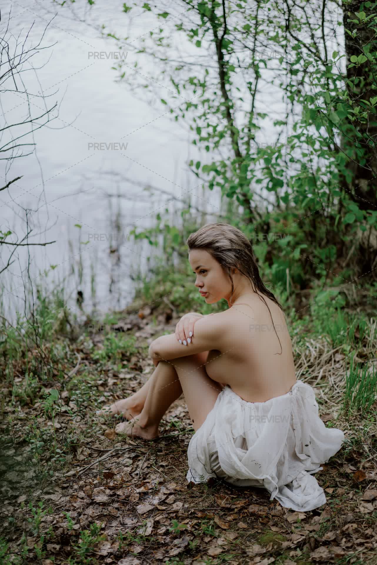 Woman Wearing A White See-Through Long Dress Near A Body Of Water In A Forest by lponline - Stock Photos | Motion Array Woman Wearing A White See-Through Long Dress Near A Body Of Water In A Forest by lponline - Stock Photos | Motion Array