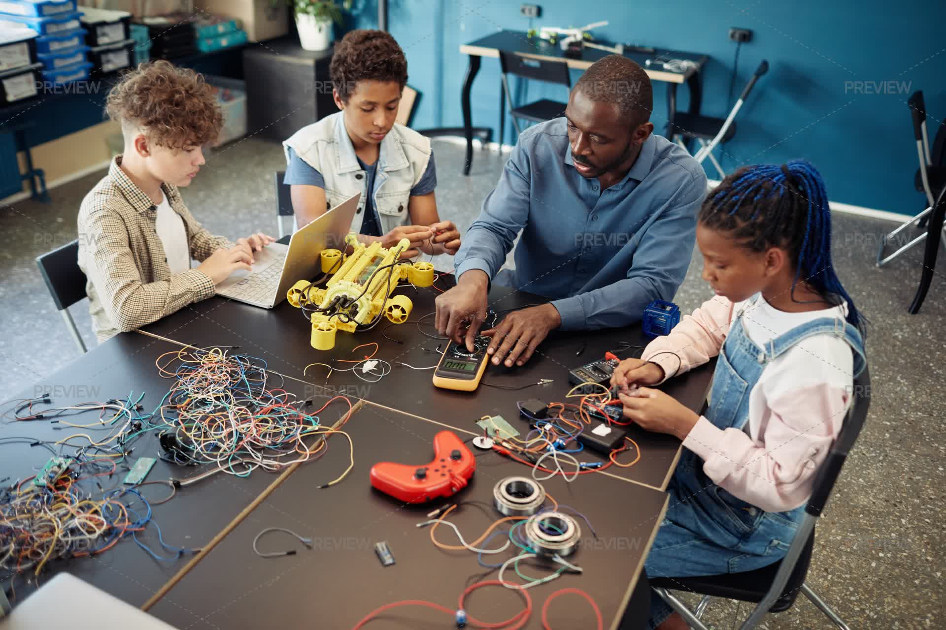 Top View Of Teacher Using Multimeter With Students In Engineering Class ...