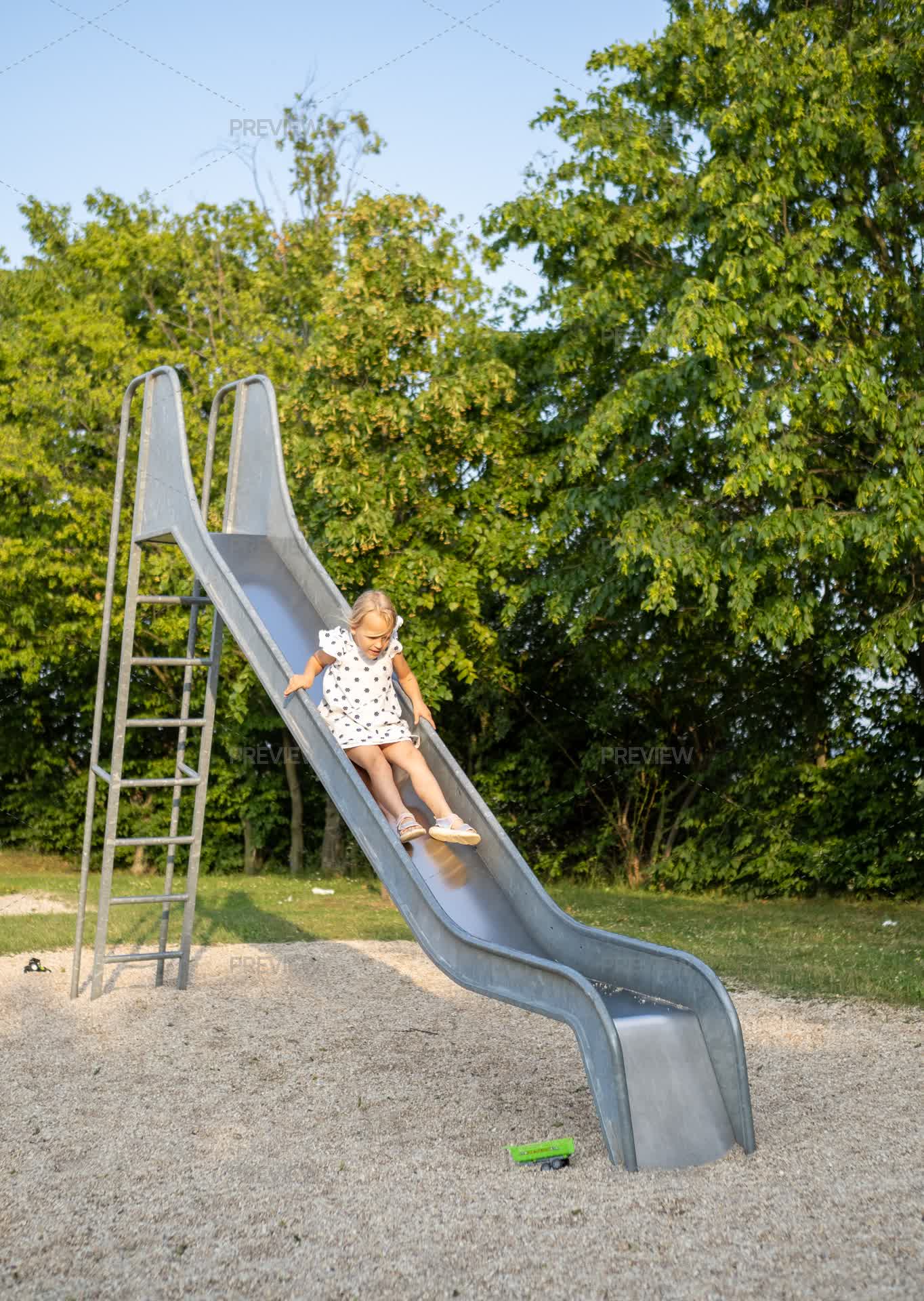 Young Child Sliding Down Metal Playground Slide by Magiclantern - Stock ...