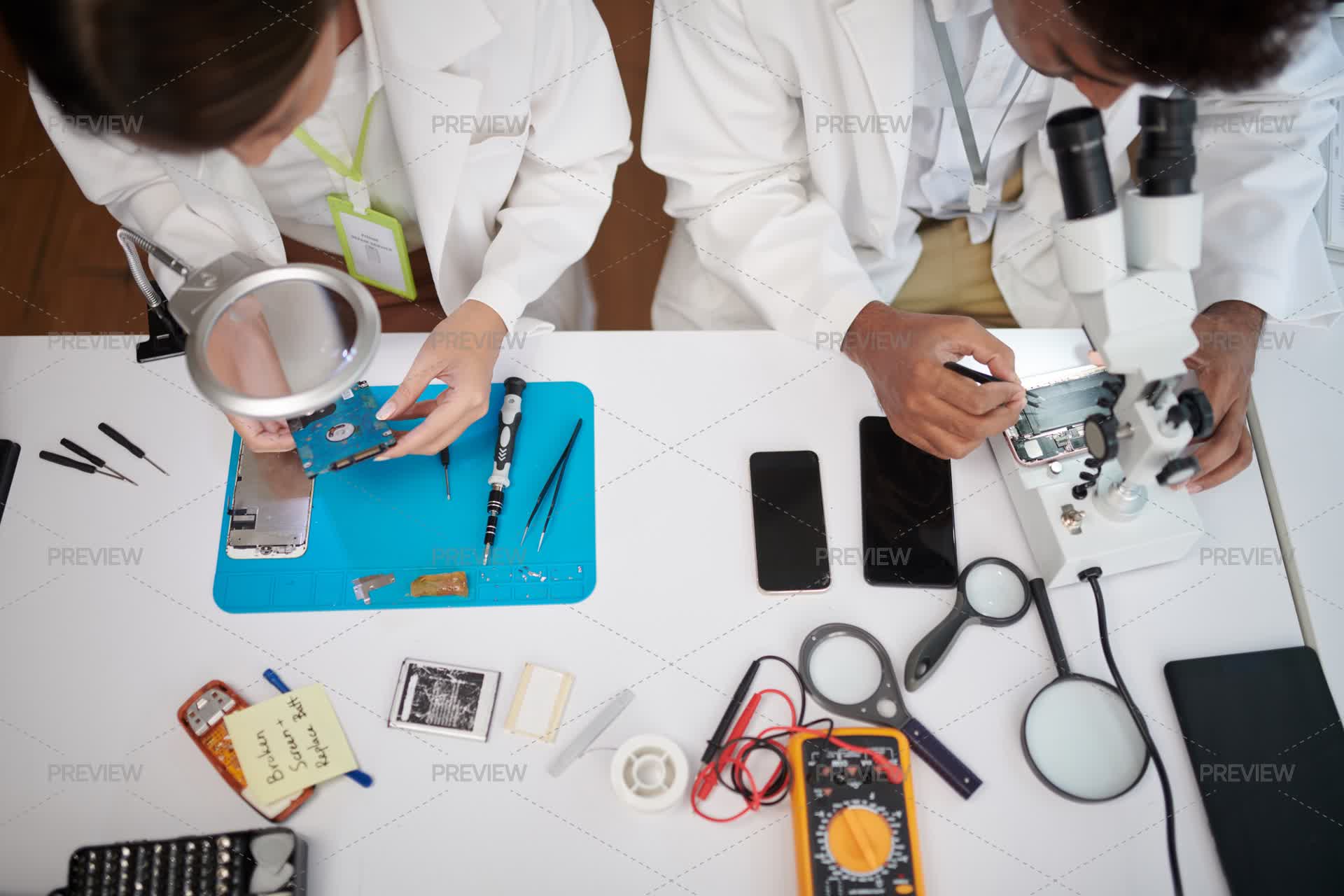 Professional Reparing Lab Service Workers Repairing Varios Devices At Table In Laboratory, View ...