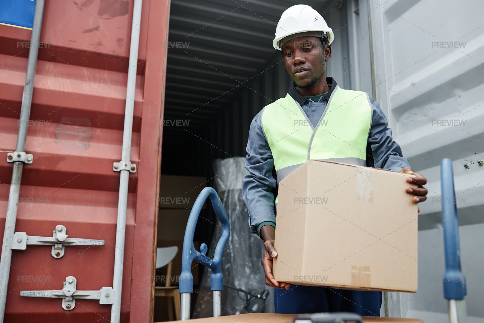 Man Unloading Boxes From Container At Shipping Docks by SeventyFour ...